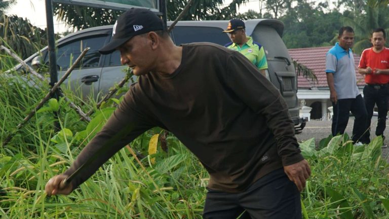 Bupati Sarolangun Hurmin Menebas Rumput Dalam Gotong Royong Berbakti Maju di Pasar Limbur Tembesi